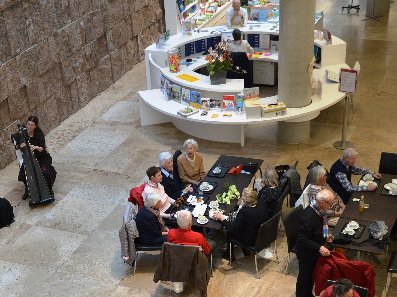 Blick von der Galerie auf das Atrium mit Harfinistin und Publikum